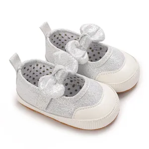 Shiny silver glitter baby walking shoes with soft soles and a large bow decoration