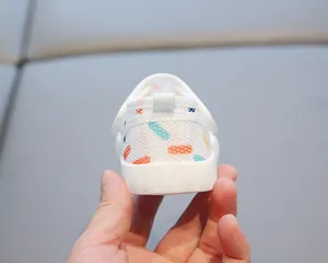 Gros plan de sandales en maille pour bébé avec tissu blanc respirant et motif coloré