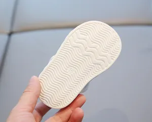 Gros plan sur la semelle ondulée antidérapante d'une sandale de marche blanche pour bébé