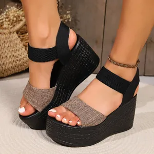 Detailed shot of women's black platform wedge sandals with textured brown fabric straps