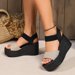 Detailed view of women's platform wedge sandals with beige linen strap and black ankle band