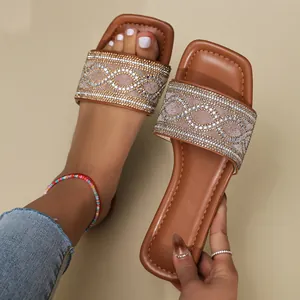 Elegante bruine platte slippers met vierkante neus en glinsterende strass-golven.