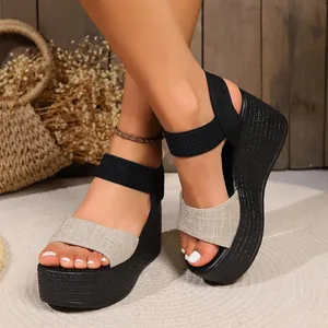 Detail view of women's black platform wedge sandals with beige canvas and elastic straps