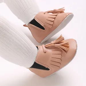Detailansicht von rosa Baby-Lauflernschuhen mit eleganten Fransen und weicher Sohle