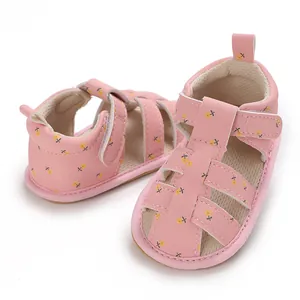 Detailweergave van roze baby prinsessen sandalen met bloemenprint en zachte zolen.