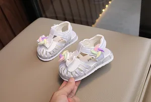 Dettaglio di sandali bianchi per bambine con girandola colorata e luci a LED
