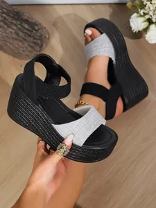 Close-up of wedge platform sandals with gray linen strap and black elastic bands.