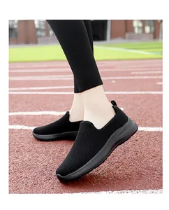 Detail view of black breathable knit slip-on sneakers for women on a running track