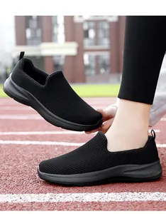 Detail shot of black breathable fly-knit mesh walking shoes on a red running track.
