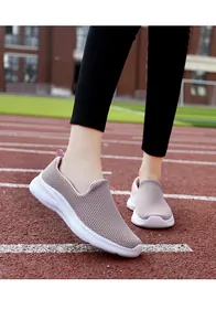 Detailed macro view of pink breathable fly-knit sneakers on a professional track
