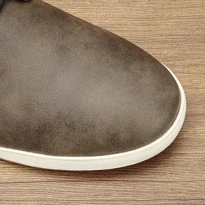 Primer plano de la puntera de cuero marrón y suela blanca de esta zapatilla de hombre