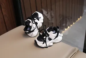 Close-up of children's black and white breathable mesh sneakers on a bench