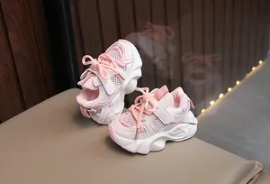 Close-up of breathable pink mesh sneakers for kids with thick wavy foam soles.