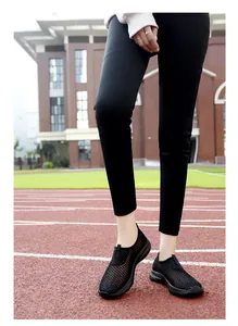 Detail shot of breathable black mesh slip-on sports shoes for women on a running track