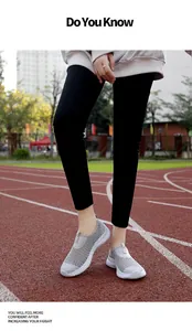 Lightweight grey mesh slip-on walking shoes for women displayed on a red track