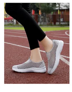 Detailed view of grey mesh breathable slip-on walking shoes on a running track.
