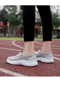 Close-up of grey breathable mesh slip-on sneakers for women on a running track.