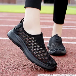 Breathable black mesh slip-on sports shoes for women shown on a red athletic track