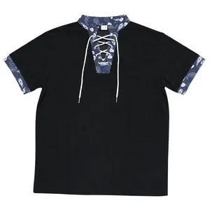 Detail view of men's loose black corduroy Henley shirt with blue paisley accents.