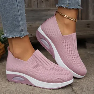 Close-up detail view of pink knit slip-on sneakers featuring a rocker sole and air cushion