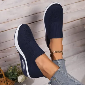 Detail of navy blue fly-knit slip-on sneakers with air cushion sole and knit texture