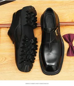 Detailed view of black leather monk shoes with thick lugged soles and gold buckle