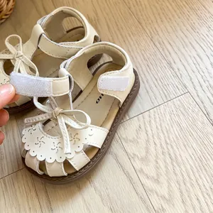 Sandales d'été crème pour bébés filles avec nœud élégant et motifs floraux ajourés