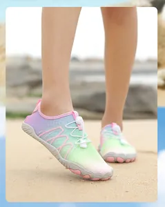 Primer plano de un modelo con zapatos de agua de colores en una playa de arena soleada