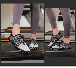 Primer plano de zapatos de agua grises y transpirables usados en una cinta de correr de gimnasio