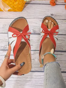 Vue détaillée des sandales à la mode pour femmes en rouge et blanc avec un nœud