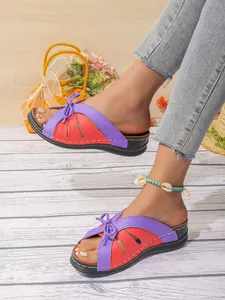 Détail de sandales compensées élégantes rouges et violettes avec un nœud pour l'été