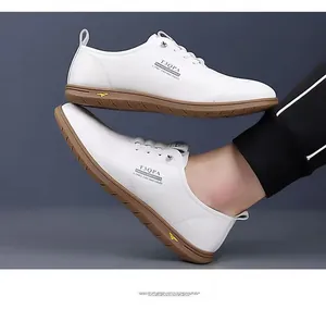 Vue détaillée de baskets blanches en cuir pour hommes avec semelle souple brune.