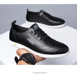 Détail des chaussures décontractées en cuir noir pour hommes avec semelles blanches souples.