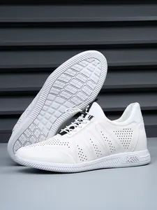 Close-up of white perforated leather sneakers for men featuring a non-slip rubber sole