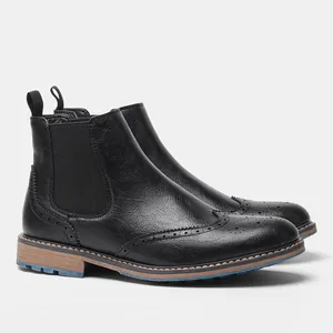 Vista lateral detallada de los botines Chelsea negros para hombre con diseño brogue tallado.