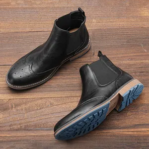 Detalle de botines Chelsea de cuero negro con diseño clásico Brogue de punta de ala