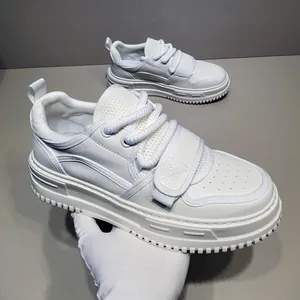 Detailansicht der weißen Herren-Sneaker mit dicker Sohle, Klettverschluss und Schnürung.
