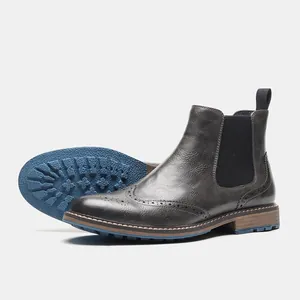 Vista detallada de botas Chelsea Brogue de cuero gris oscuro con suelas azules
