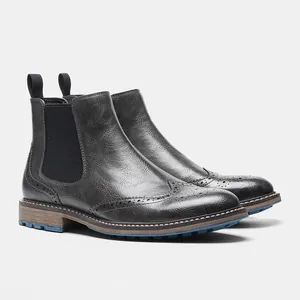 Primer plano de botines Chelsea de cuero negro con detalles brogue y paneles laterales elásticos
