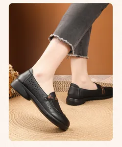 Side view of black breathable hollowed-out soft-bottom loafers for women on a rug