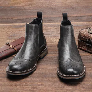 Vista detallada de los botines Chelsea de cuero gris vintage con tallado brogue