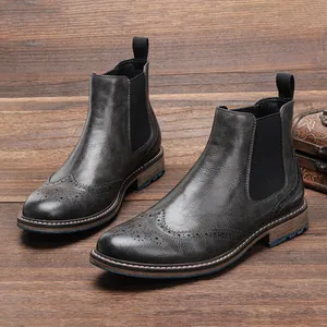 Detalle de botines Chelsea vintage para hombre con tallado de estilo brogue británico.