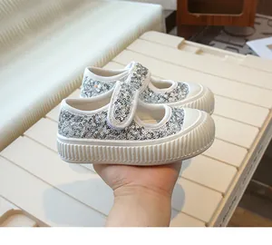 Detailed macro view of sparkly silver sequined canvas Mary Jane shoes for little girls