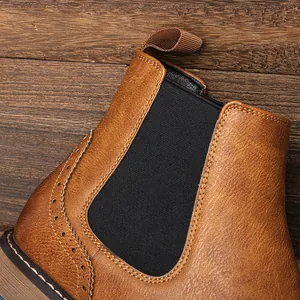 Primer plano de botas Chelsea de cuero marrón con elegantes detalles brogue tallados