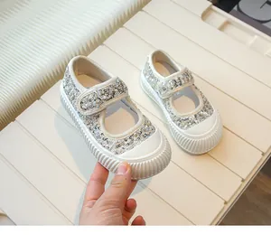 Close-up of girls' silver sequin Mary Jane shoes with velcro strap and white rubber toe
