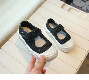 Detailed view of fashionable black sequined girls' Mary Jane shoes with white soles