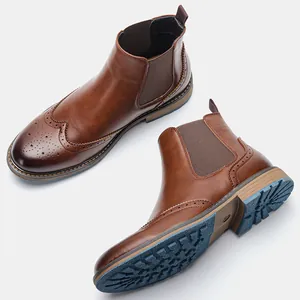 Detalle de botas Chelsea brogue marrones para hombre con puntera vega y suela grabada.