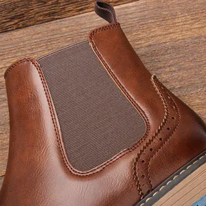Primer plano de botas Chelsea de cuero marrón vintage con elegantes tallas tipo Brogue.