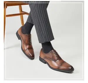 Elegant men's brown leather oxford dress shoes with cap-toe detail and classic lace-up design