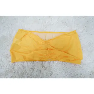 Close-up of a bright yellow ruched mesh bandeau top presented on a white faux fur background
